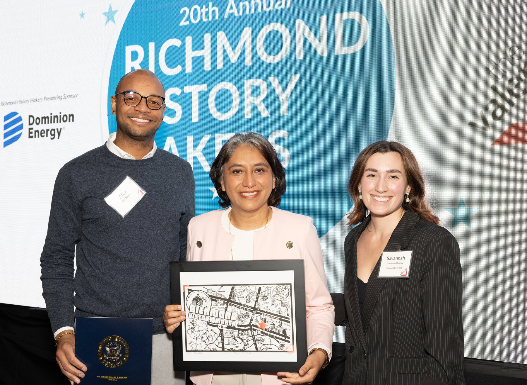 Elvira sosteniendo su reconocimiento Richmond History Maker junto a representantes del evento